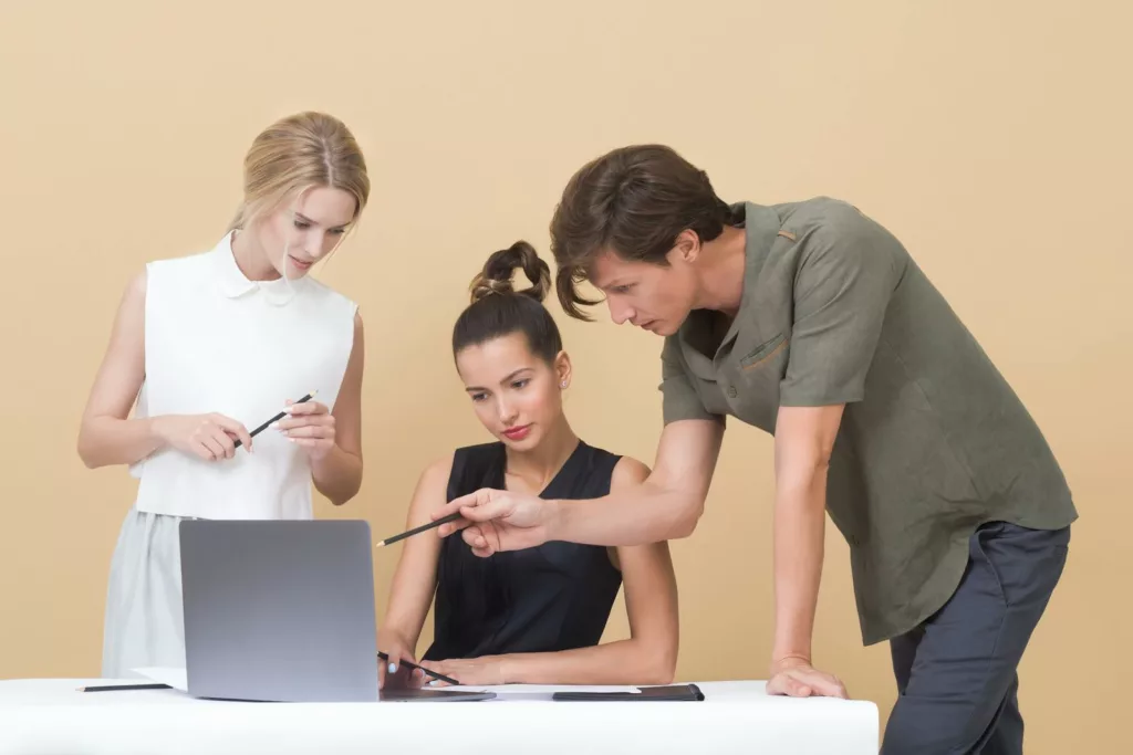 Photo de plusieurs collègues , échangeant des idées et des suggestions, représentant un environnement de travail où la critique est vue comme une opportunité d'amélioration.