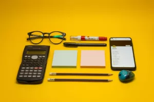 Maths – matériel scolaire avec calculatrice, stylo, lunettes, carnet et crayons illustrant les cours de mathématiques